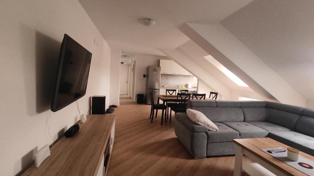 een woonkamer met een bank en een tafel bij Deniro Apartment in Požega