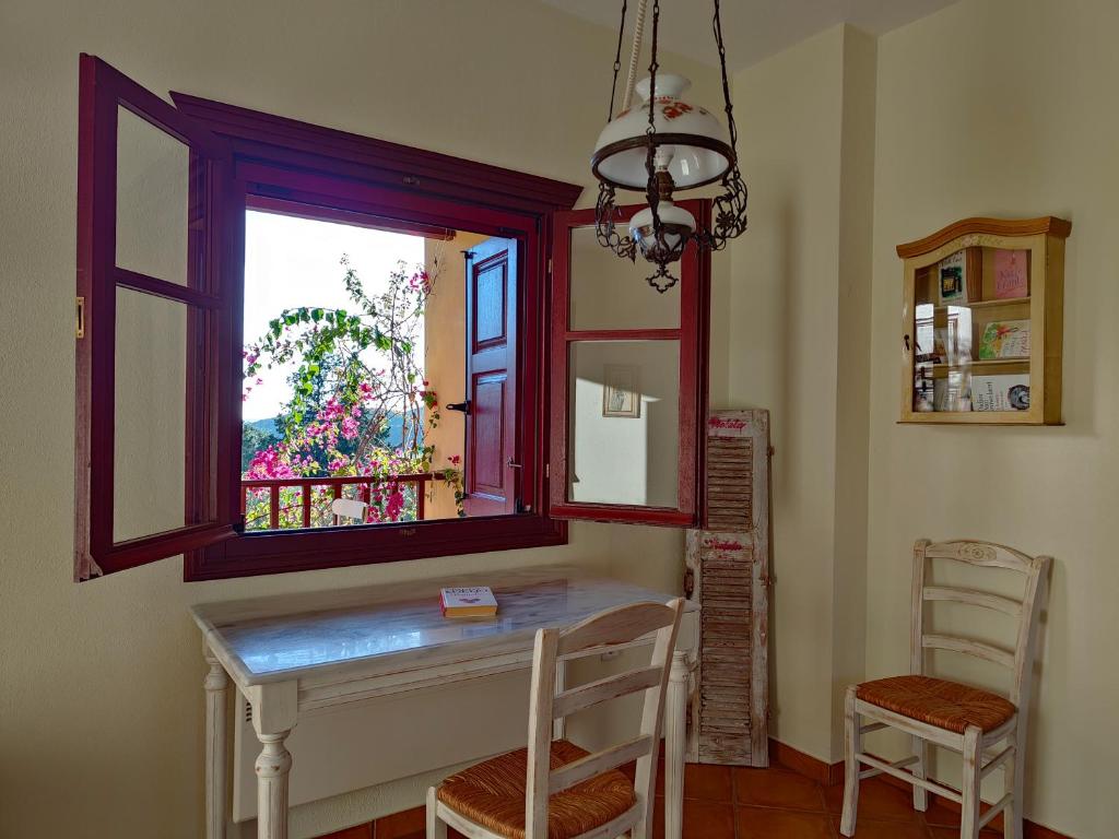 a dining room with a table and a window at Alkyon Villas in Syvota