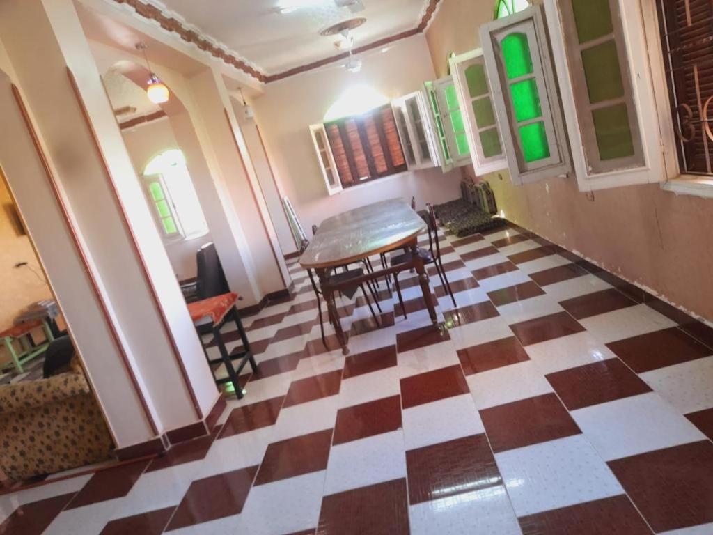 a room with a checkered floor with a table and chairs at Algaafary GeustHouse in Aswan