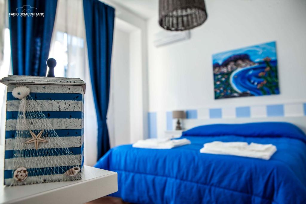 Schlafzimmer mit blauem Bett und blauen Vorhängen in der Unterkunft Ciuri Ciuri B&B in Palermo