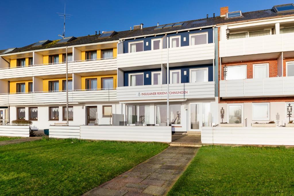 a building with a lawn in front of it at Insulaner Ferienwohnungen in Helgoland