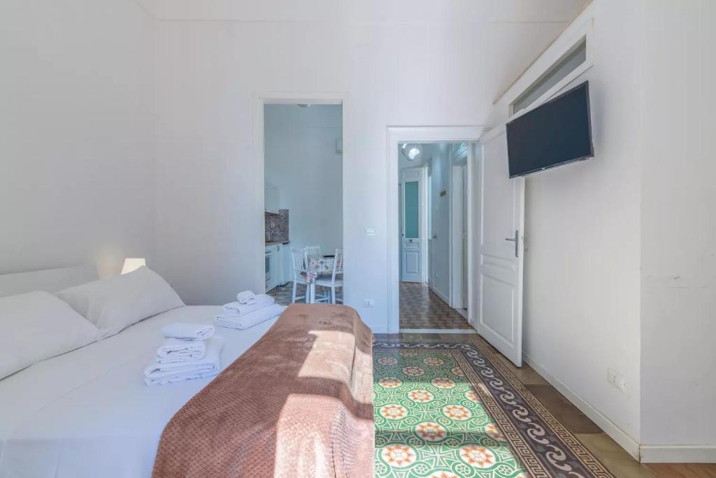 a white room with a bed and a television at Hotiday Siracusa A'Storia in Syracuse