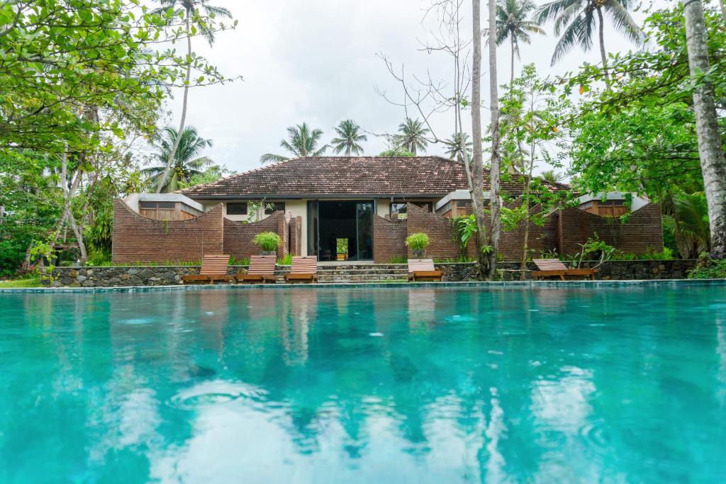 a resort with a swimming pool in front of a house at The Spice Trail, Ahangama in Ahangama