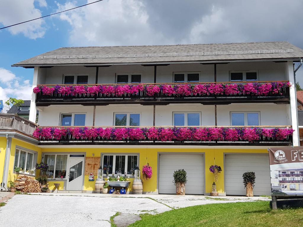 una casa amarilla y blanca con flores rosas en Ferienhaus Brenner, en Sankt Kathrein am Offenegg