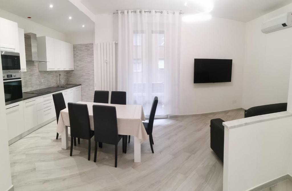 ミラノにあるResidenze Niguarda Eのテーブルと椅子のあるキッチンとダイニングルーム