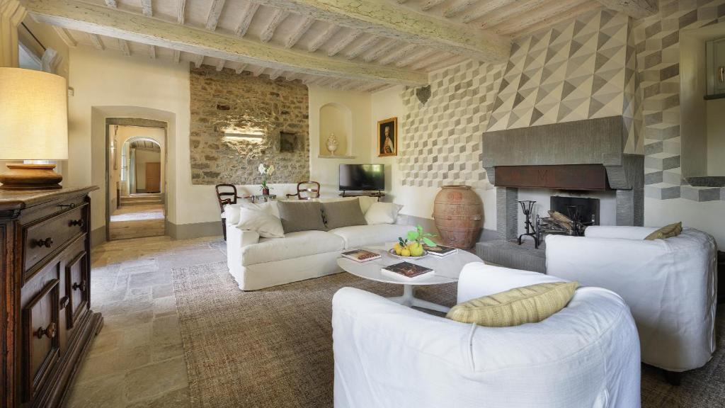 salon z białymi meblami i kominkiem w obiekcie VILLA METELLIANO 10, Emma Villas w mieście Cortona