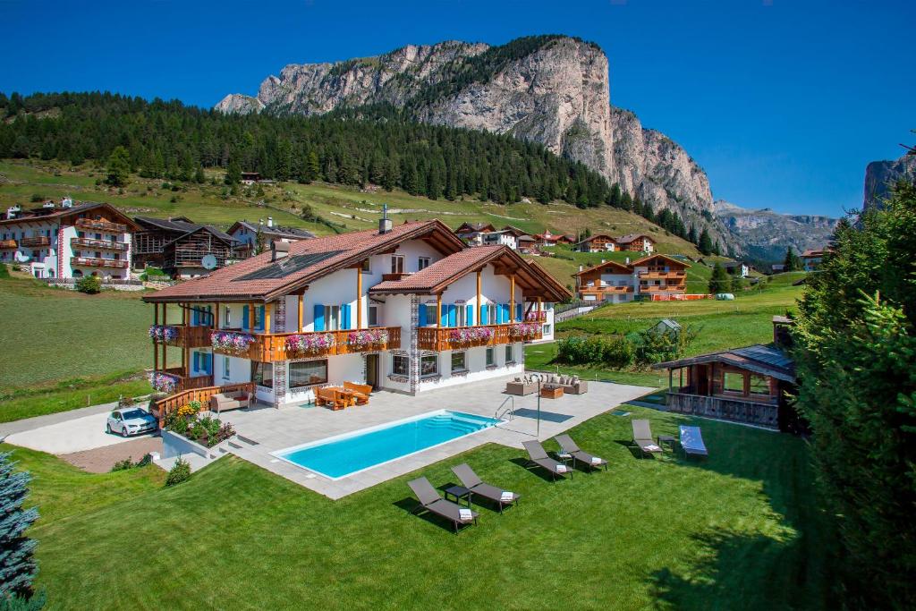 an aerial view of a house with a swimming pool at Garni Petra in Selva di Val Gardena