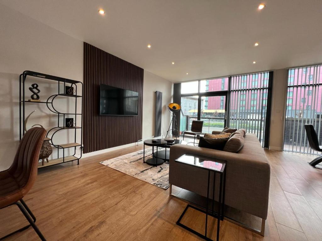 a living room with a couch and a tv at Stunning Apartment at Glasgow Hydro & SECC - Glasg in Glasgow