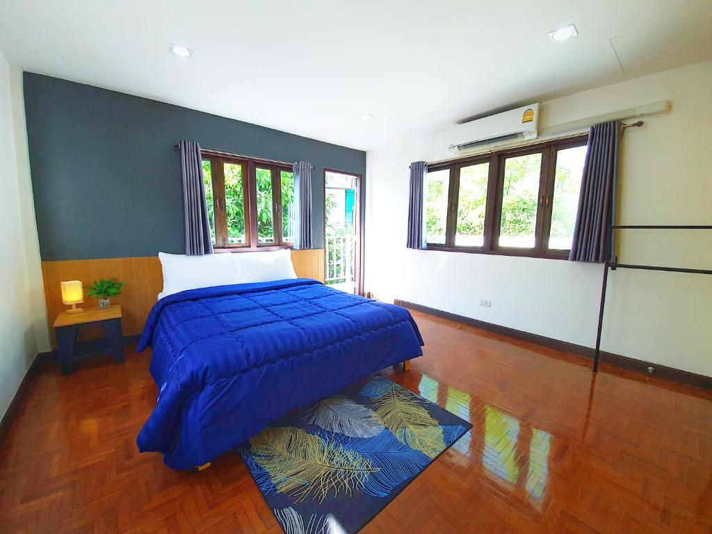 une chambre avec un lit recouvert d'une couette bleue dans l'établissement Doodle Lodge Chiang Mai, à Chiang Mai