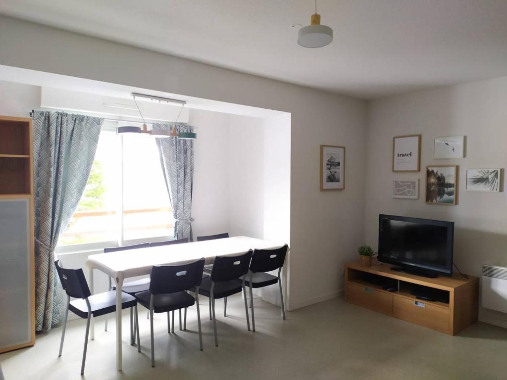 ein Wohnzimmer mit einem Tisch, Stühlen und einem TV in der Unterkunft Appartement Arette, 3 pièces, 6 personnes - FR-1-602-61 in Arette