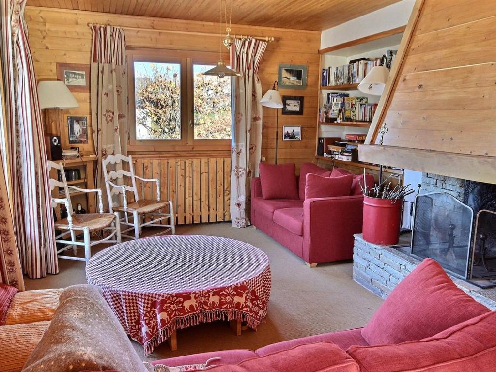 a living room with a red couch and a fireplace at Chalet Peisey-Vallandry, 5 pièces, 10 personnes - FR-1-411-683 in Landry