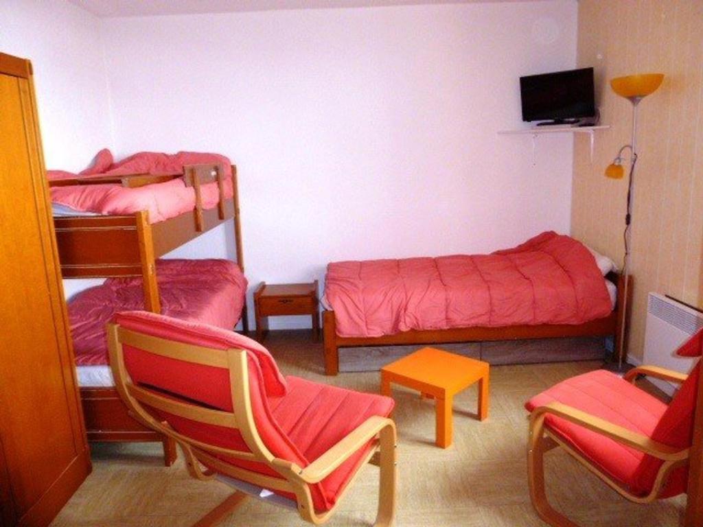 Cette petite chambre comprend 2 lits superposés et une chaise. dans l'établissement Studio pour 4 pers., pied des pistes à La Pierre St Martin, commerces à proximité, parking gratuit - FR-1-602-6, à Arette