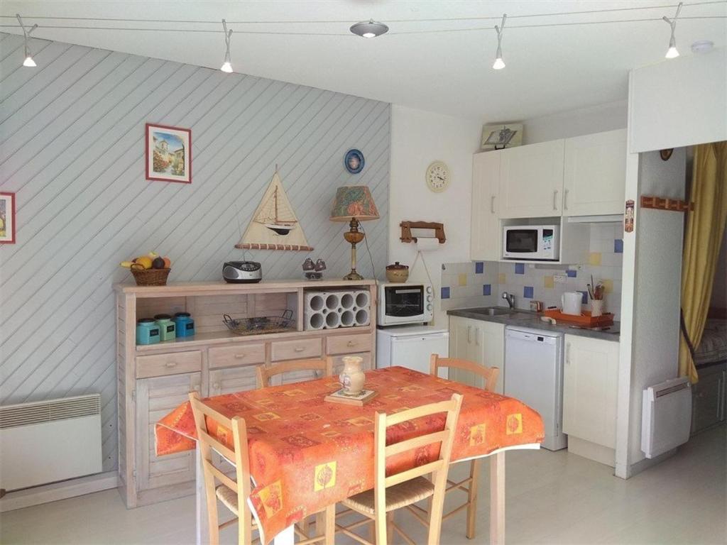 a kitchen with a table and a table and chairs at Studio Piau-Engaly, 1 pièce, 6 personnes - FR-1-457-200 in Aragnouet