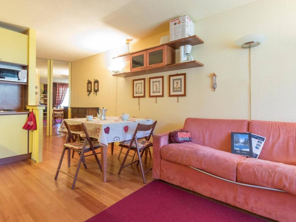 uma sala de estar com um sofá vermelho e uma mesa em Appartement Montgenèvre, 2 pièces, 6 personnes - FR-1-330D-7 em Montgenèvre