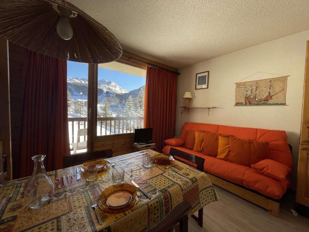 uma sala de estar com um sofá e uma mesa em Appartement Montgenèvre, 1 pièce, 3 personnes - FR-1-330D-35 em Montgenèvre