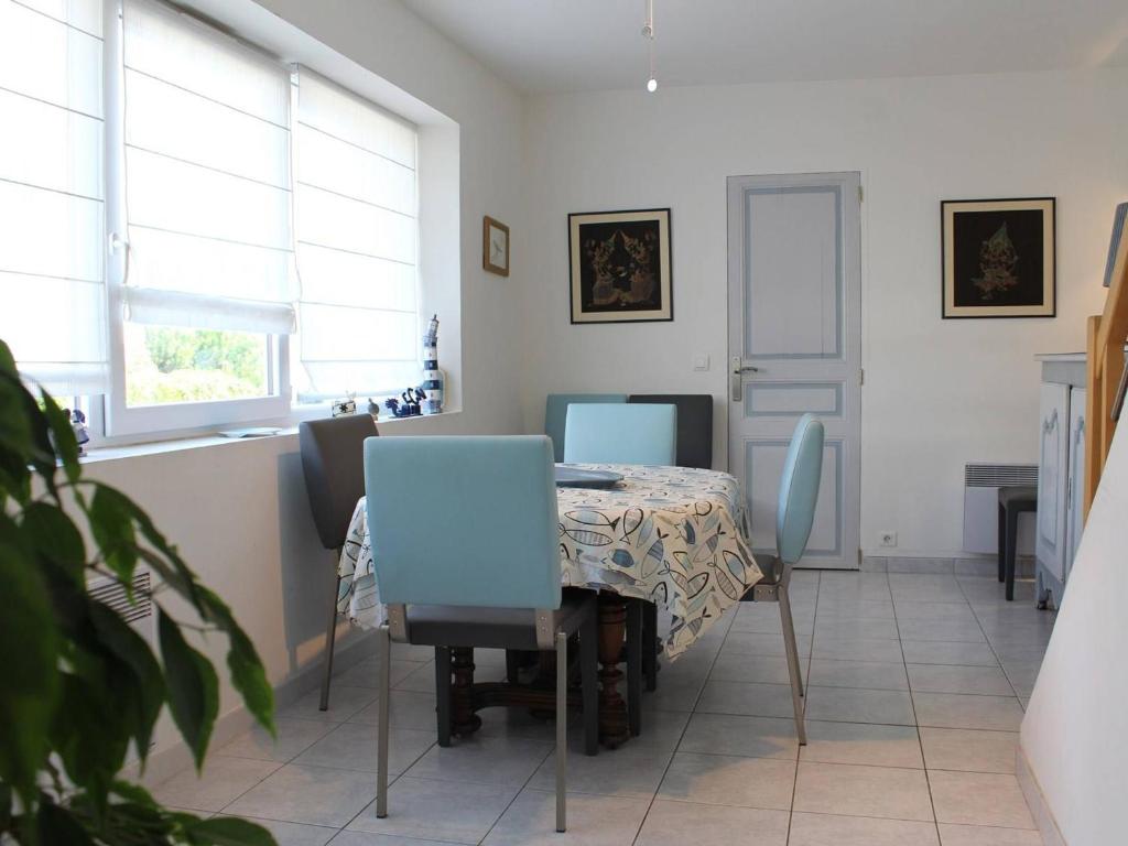 une salle à manger avec une table et des chaises bleues dans l'établissement Maison 3 niveaux, 6 couchages, La Baule, proche plage et commerces, terrasses privées - FR-1-245-150, à La Baule