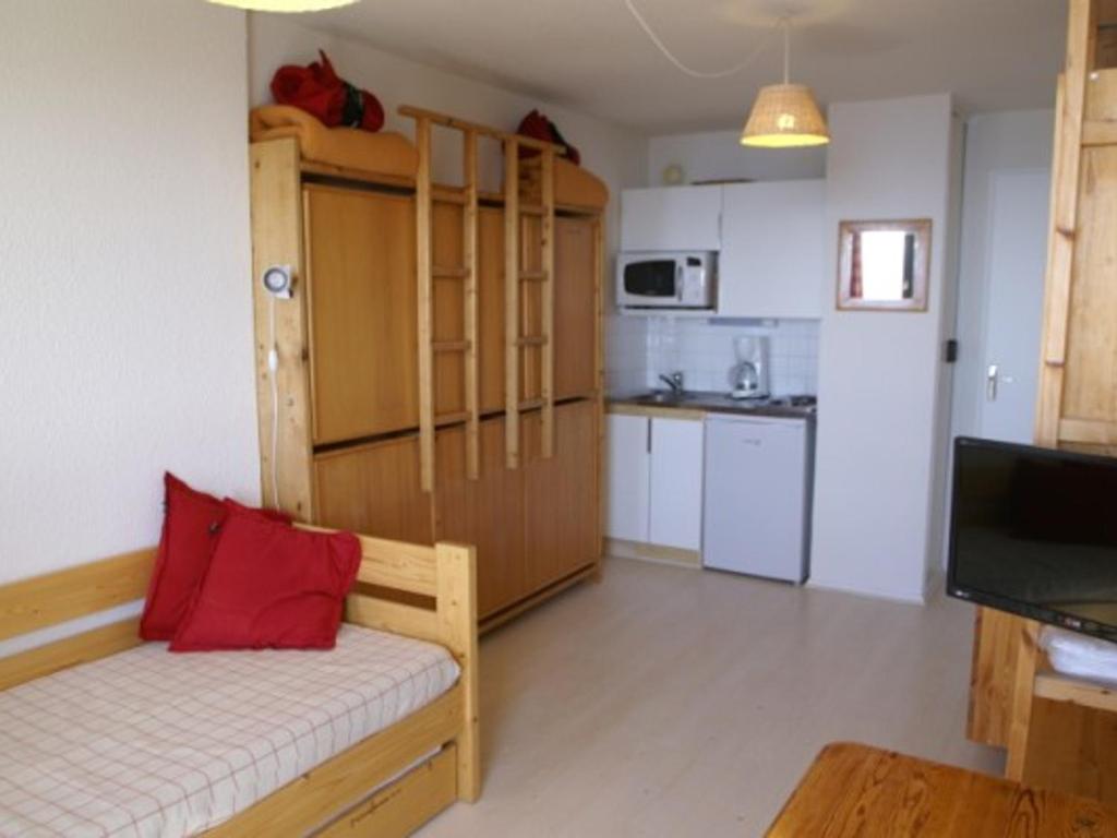 una pequeña sala de estar con una almohada roja en un sofá en Appartement Les Adrets-Prapoutel, 1 pièce, 3 personnes - FR-1-557-80, en Les Adrets