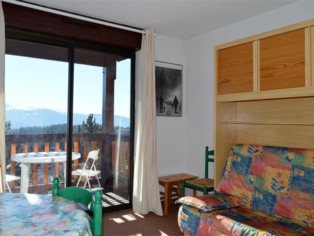 a living room with a couch and a balcony at Studio Bolquère-Pyrénées 2000, 1 pièce, 4 personnes - FR-1-592-14 in Bolquere Pyrenees 2000