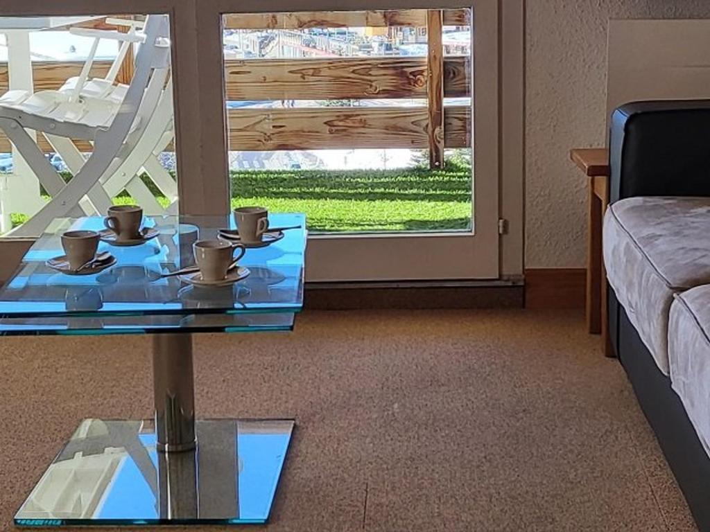 - un salon doté d'une table en verre avec des tasses dans l'établissement Appartement lumineux 6 pers, pied des pistes, balcon sud, ascenseur, proche commerces, Palais des Sports - FR-1-262-176, à Orcières