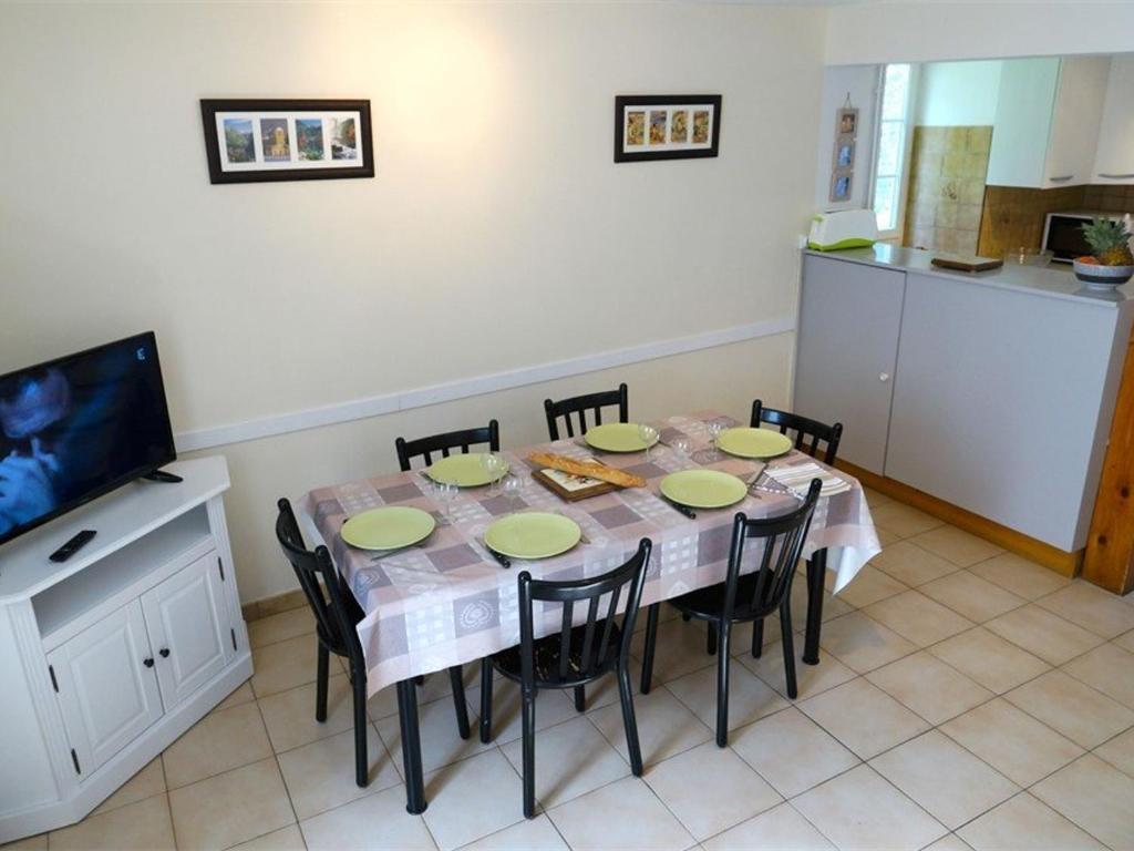 a dining room with a table with chairs and a television at Maison Bagnères-de-Luchon, 4 pièces, 6 personnes - FR-1-313-158 in Luchon