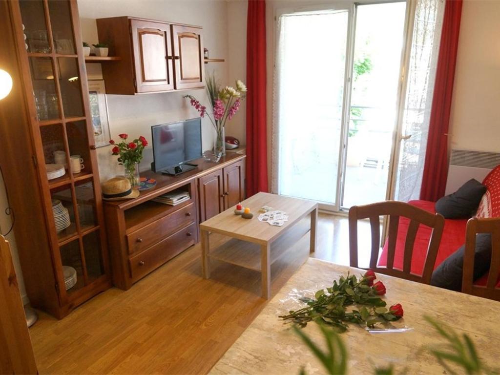 uma sala de estar com uma mesa e uma televisão em Appartement Bagnères-de-Luchon, 3 pièces, 4 personnes - FR-1-313-186 em Luchon