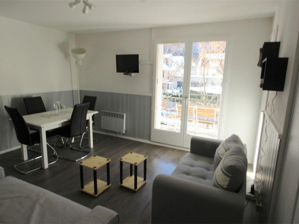 uma sala de estar com um sofá e uma mesa em Appartement Bagnères-de-Luchon, 2 pièces, 4 personnes - FR-1-313-159 em Luchon