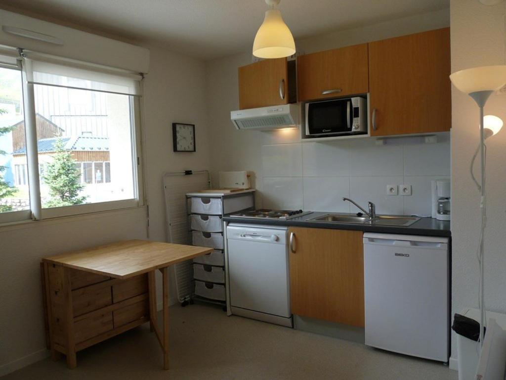 a small kitchen with a sink and a table at Appartement cosy 4 pers. sur les pistes, parking gratuit, casier à skis, lave-vaisselle, lave-linge - FR-1-602-47 in Arette