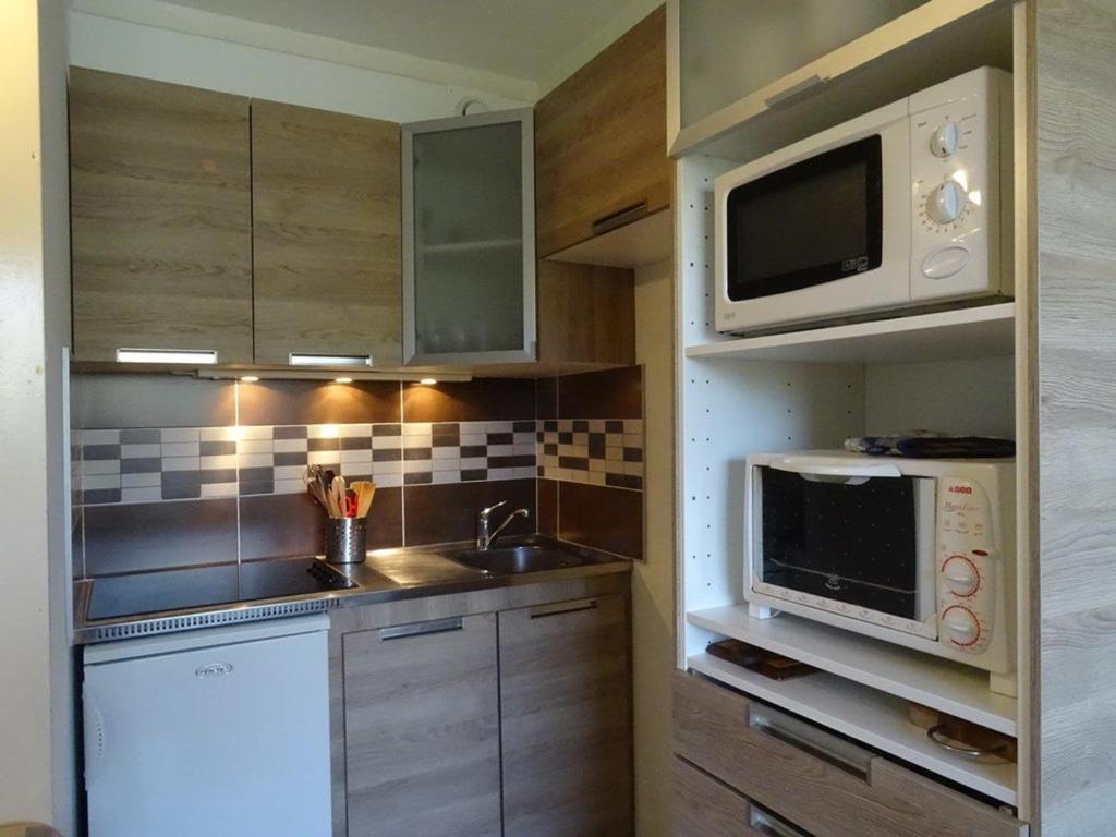 une petite cuisine avec un évier et un micro-ondes dans l'établissement Studio pour 4 pers. à proximité des pistes avec balcon et parking - FR-1-602-55, à Arette