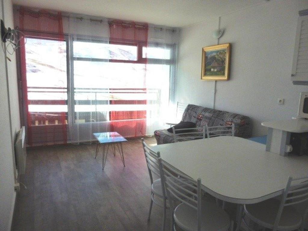 un soggiorno con tavolo, sedie e divano di Appartement Arette, 2 pièces, 6 personnes - FR-1-602-46 ad Arette