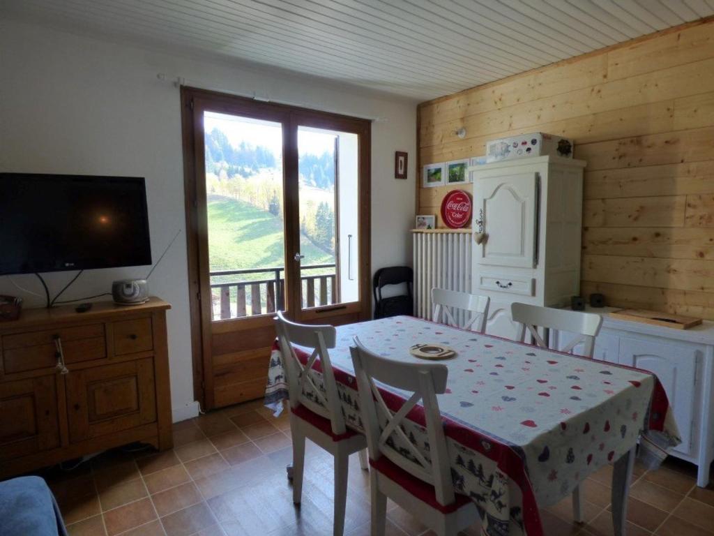 une cuisine avec une table et des chaises ainsi qu'une télévision dans l'établissement Appartement Le Grand-Bornand, 3 pièces, 6 personnes - FR-1-458-90, au Grand-Bornand