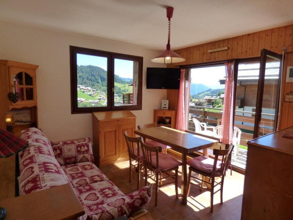 a living room with a couch and a table with chairs at Appartement Le Grand-Bornand, 2 pièces, 6 personnes - FR-1-458-108 in Le Grand-Bornand