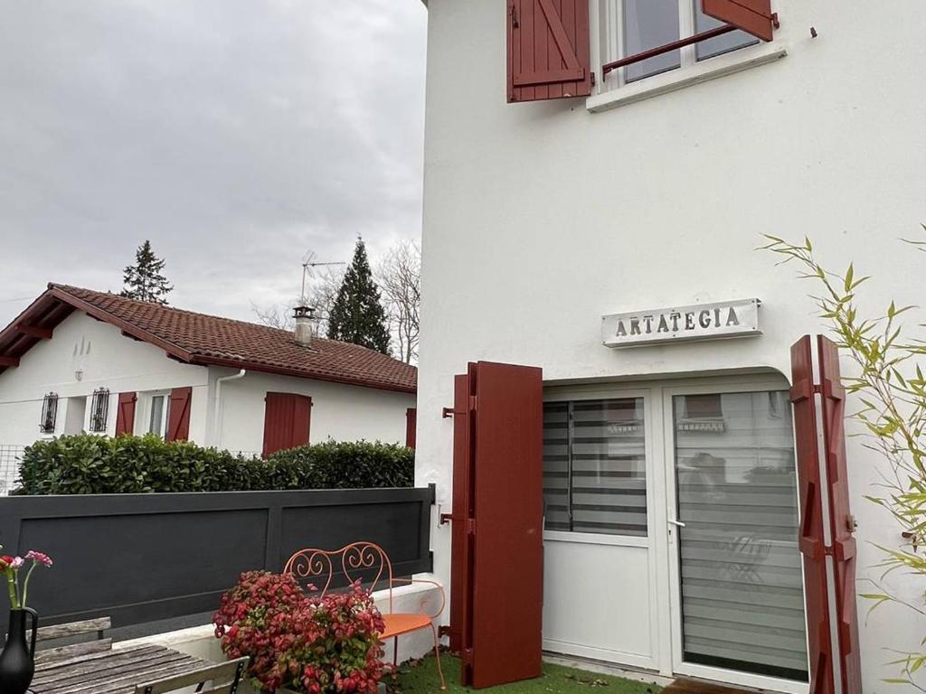 uma casa branca com um portão e um edifício com uma janela em Appartement Cambo-les-Bains, 2 pièces, 2 personnes - FR-1-495-94 em Cambo-les-Bains