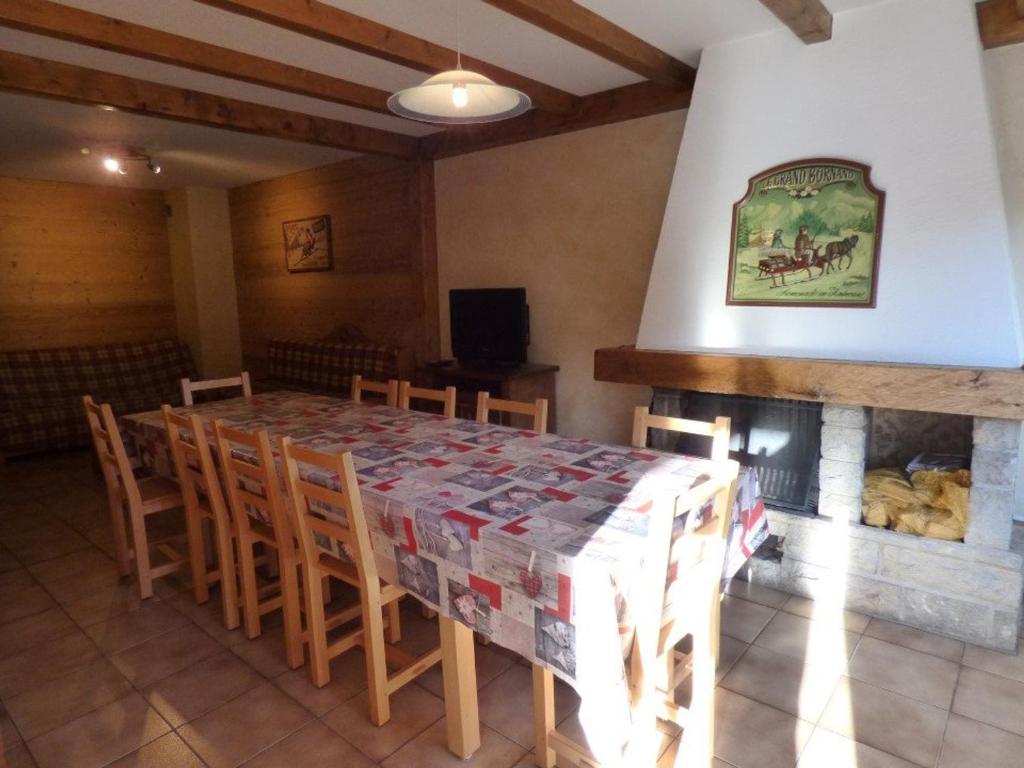 une salle à manger avec une table, des chaises et une cheminée dans l'établissement Appartement Le Grand-Bornand, 6 pièces, 11 personnes - FR-1-458-137, au Grand-Bornand