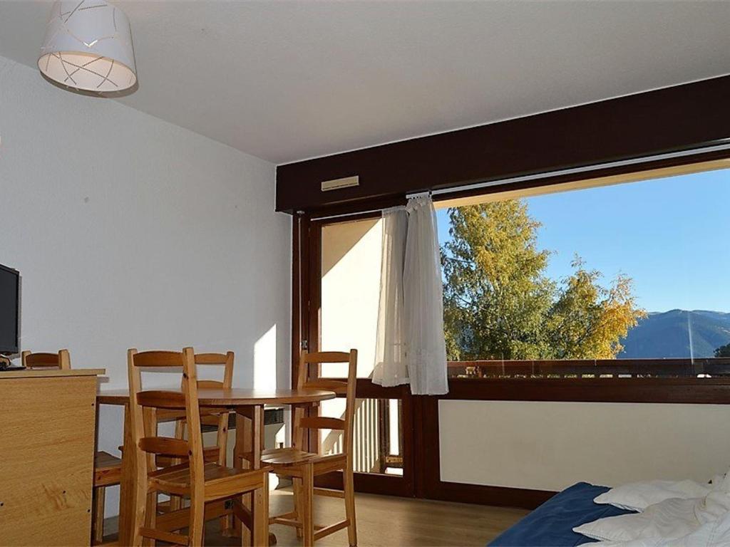 une pièce avec une table, des chaises et une fenêtre dans l'établissement Charmant 2 Pièces Cabine Sud avec Jardin, Balcon & Proche Cœur de Station - FR-1-580-29, à Font-Romeu-Odeillo-Via
