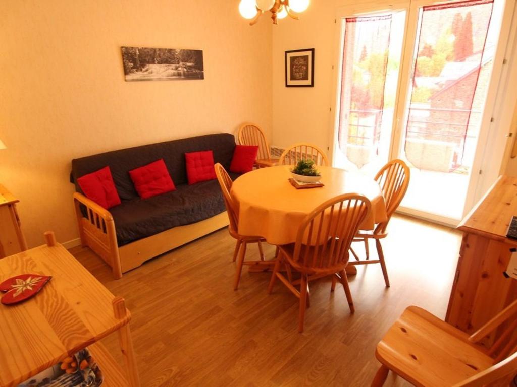 a living room with a table and a couch at Appartement Bagnères-de-Luchon, 2 pièces, 4 personnes - FR-1-313-170 in Luchon