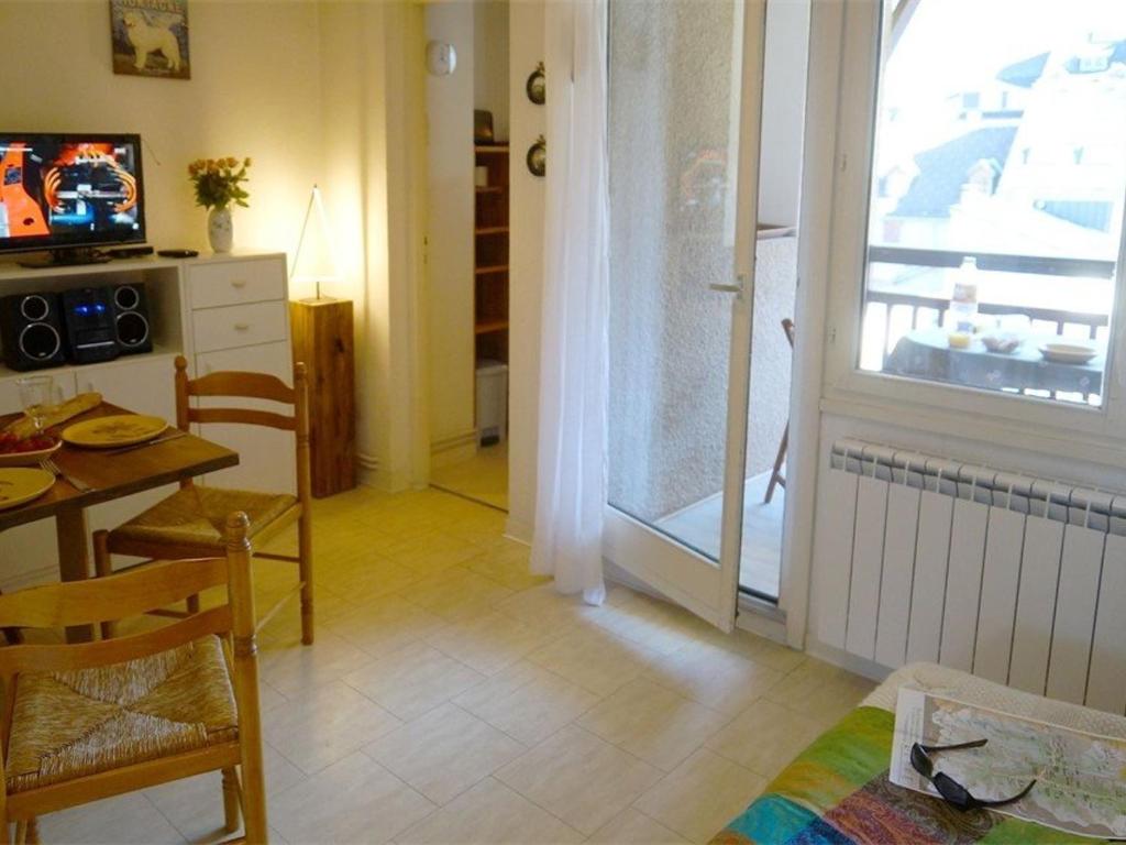 a living room with a table and a kitchen with a window at Studio Bagnères-de-Luchon, 1 pièce, 4 personnes - FR-1-313-149 in Luchon