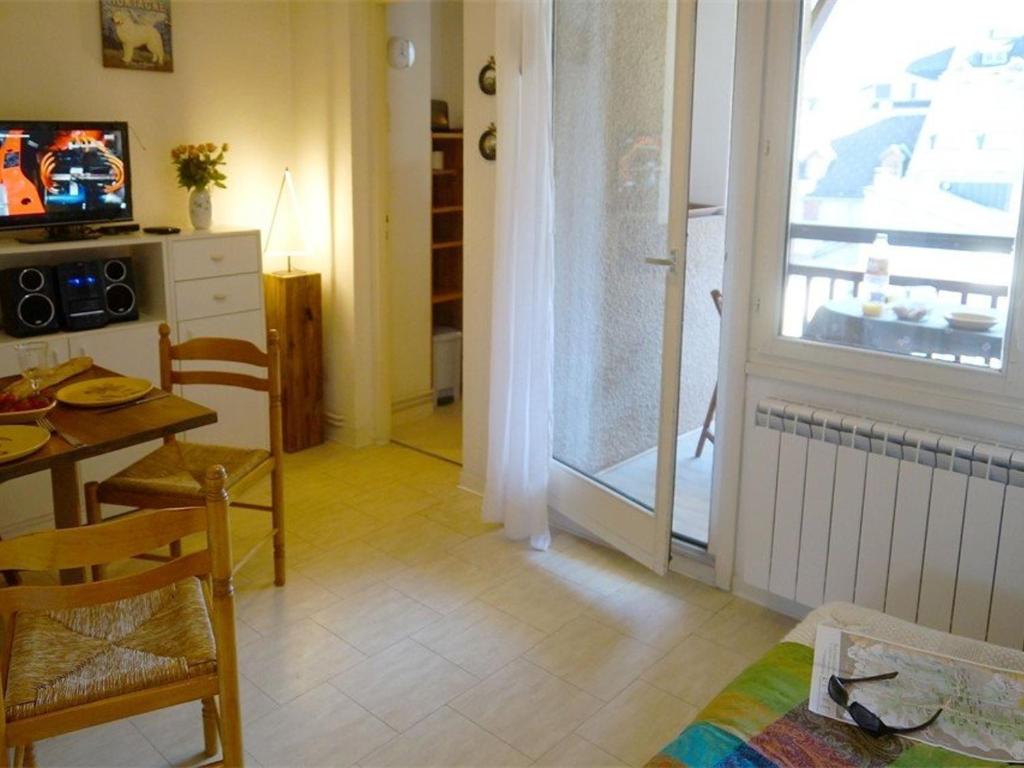 un salon avec une table et une cuisine avec une fenêtre dans l'établissement Studio Calme avec Balcon Plein Sud, Parking Privé, Proche Thermes et Centre-ville - FR-1-313-149, à Luchon