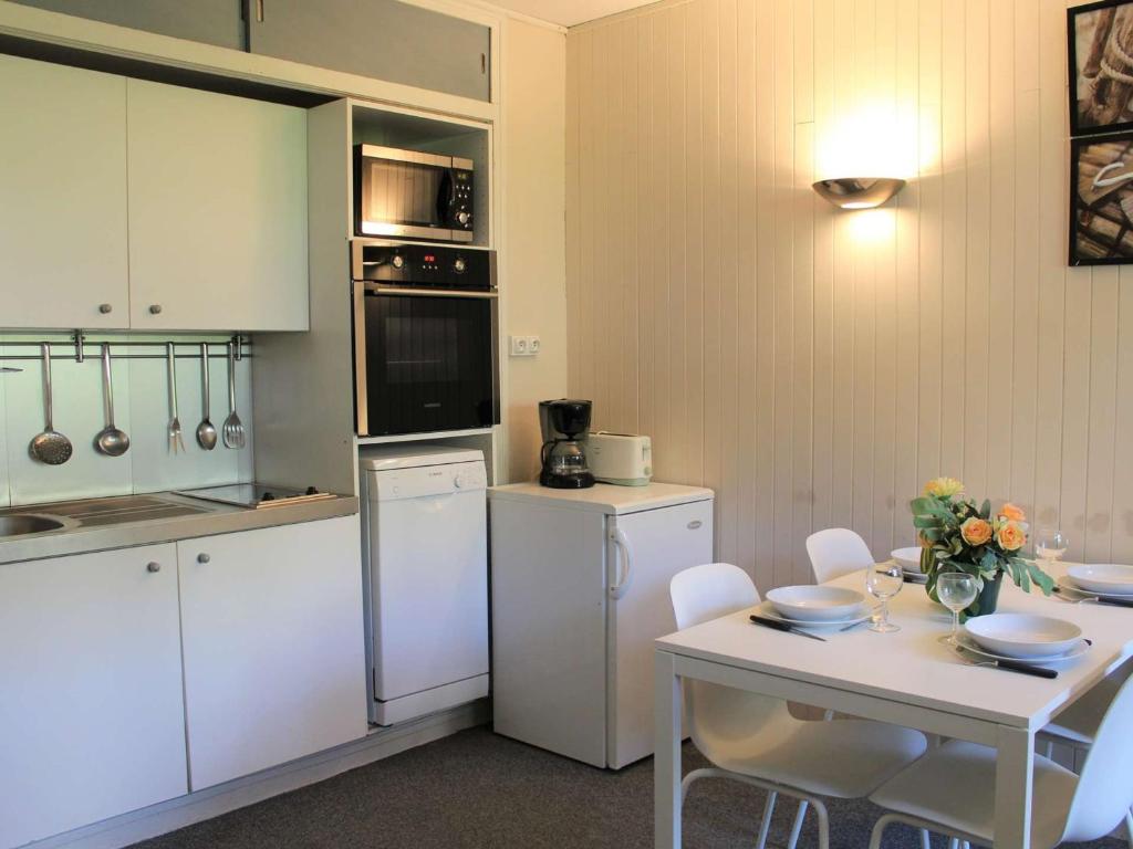 a kitchen with white appliances and a table with chairs at Appartement Vars, 1 pièce, 4 personnes - FR-1-330B-179 in Vars