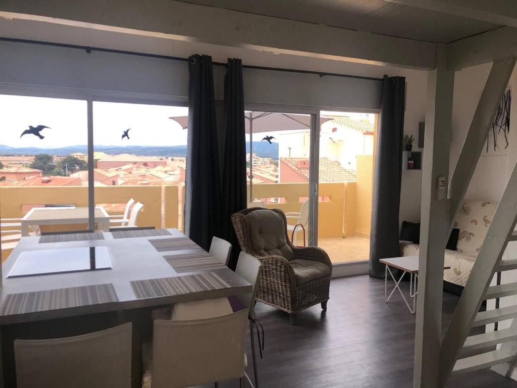 une salle à manger avec une table et des chaises et un balcon dans l'établissement Appartement avec terrasse, 4 couchages, plage à proximité, parking - FR-1-81-536, à Port-Leucate