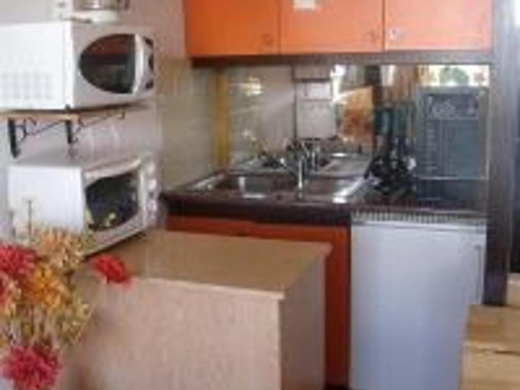 une cuisine avec un évier et un micro-ondes dans l'établissement Studio cosy 4 personnes au pied des pistes avec parking et casier à skis - FR-1-602-49, à Arette