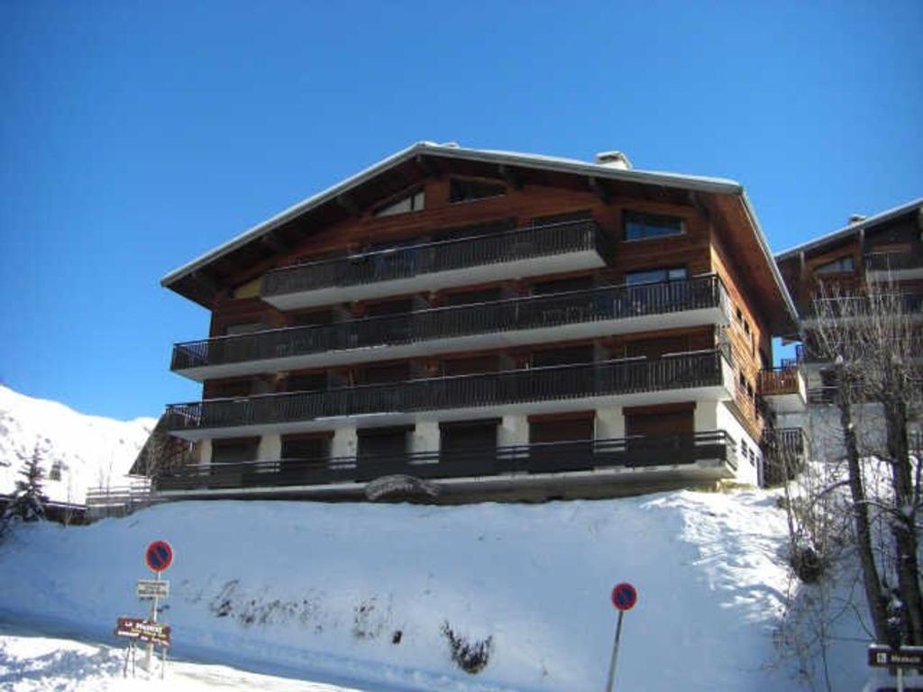 un grand bâtiment avec de la neige devant lui dans l'établissement Studio cosy ski aux pieds avec balcon, garage, et 300m des commerces (4 pers, 27m²) - FR-1-458-105, au Grand-Bornand