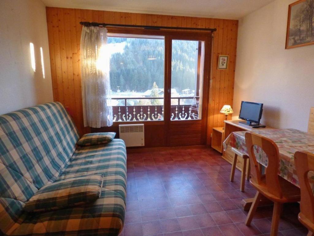 een woonkamer met een bank, een tafel en een raam bij Appartement Le Grand-Bornand, 2 pièces, 6 personnes - FR-1-458-139 in Le Grand-Bornand