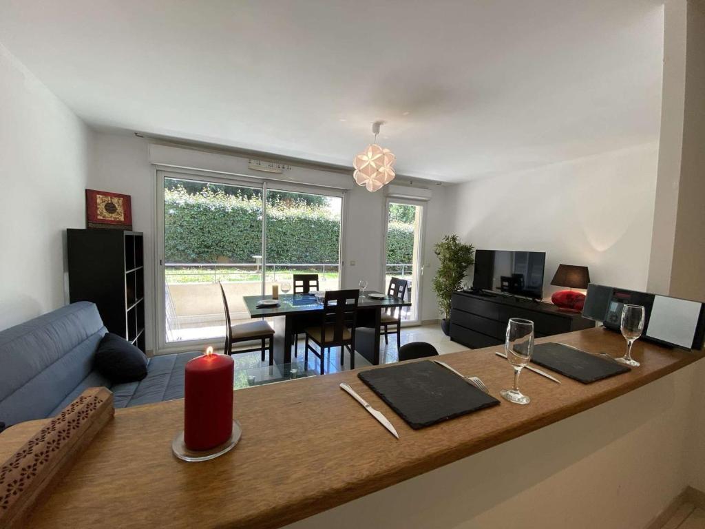 - un salon avec une table et une bougie rouge dans l'établissement Appartement 3P avec Terrasse et Garage, à 10min des Plages de Juan-les-Pins - FR-1-252-171, à Antibes