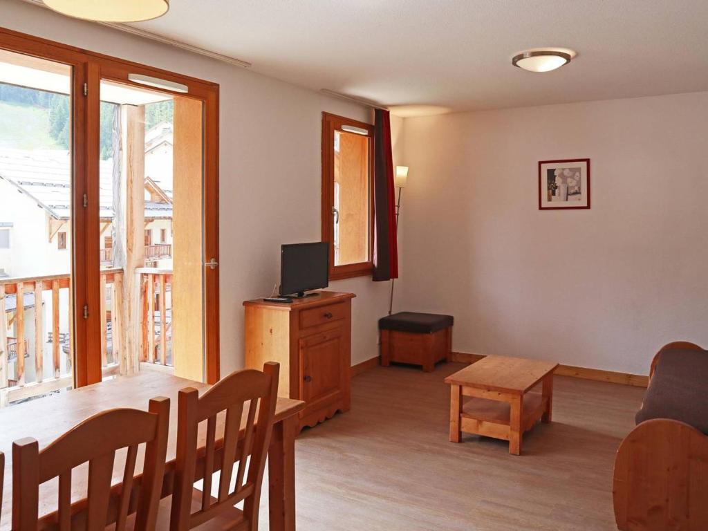 ein Wohnzimmer mit einem Tisch und einem TV in der Unterkunft Appartement Les Orres, 3 pièces, 10 personnes - FR-1-322-424 in Les Orres