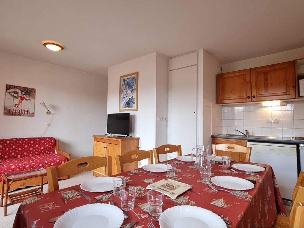 una cucina con tavolo, piatti e bicchieri di Appartement Le Dévoluy, 4 pièces, 8 personnes - FR-1-525-179 a Le Dévoluy