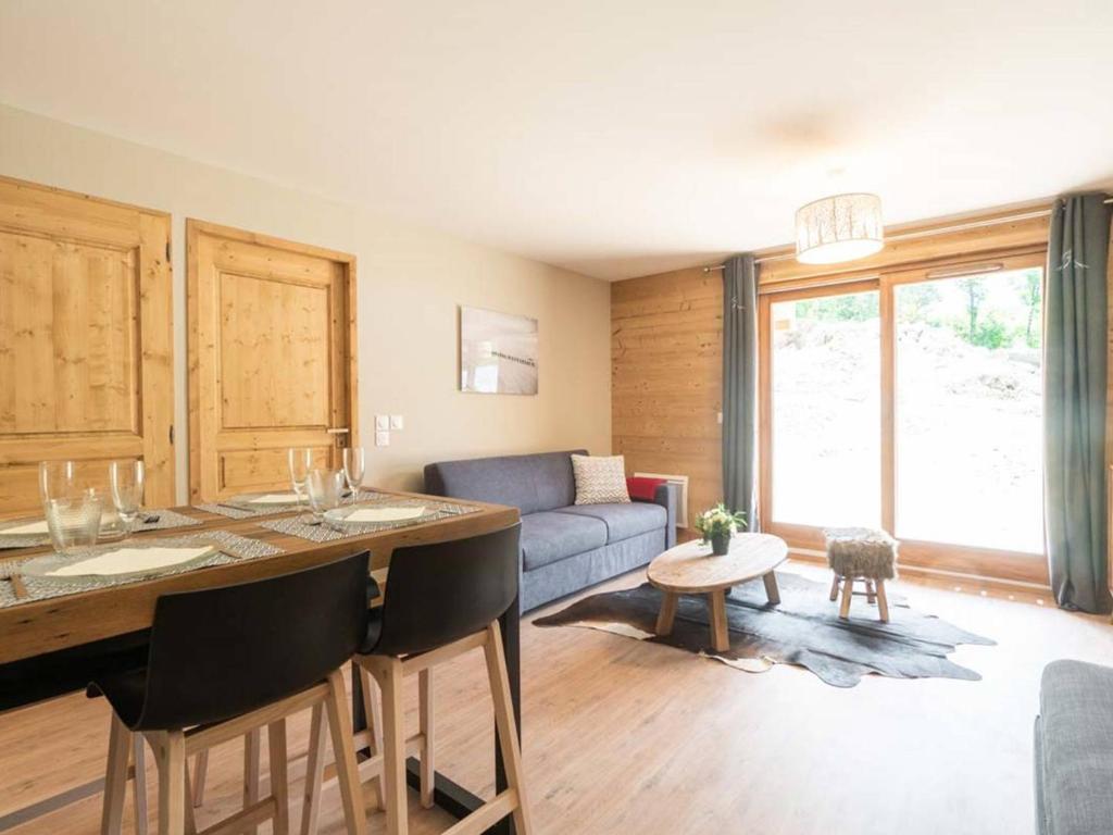 ein Wohnzimmer mit Tisch und Couch in der Unterkunft Charmette 2 pièces avec parking, terrasse et casier à skis - FR-1-291-860 in Valmorel