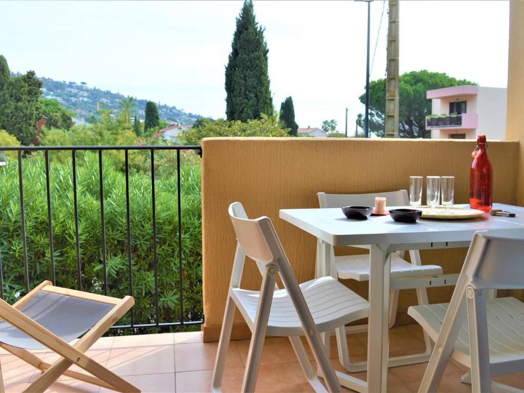 une table blanche et des chaises sur un balcon dans l'établissement Studio 4 pers à 500m de la Plage de Saint-Clair, 3 étoiles, Parking Inclus, Ménage Offert - FR-1-251-398, au Lavandou