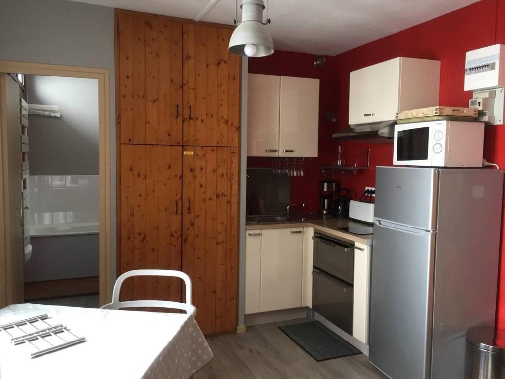 una cucina con elettrodomestici bianchi e pareti rosse di Studio pour 4 personnes avec ascenseur, parking gratuit et accès direct aux pistes - FR-1-602-82 ad Arette