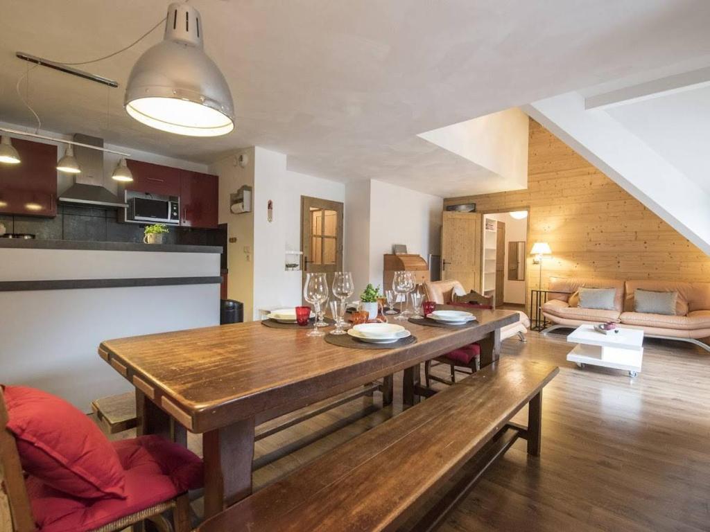 a kitchen and living room with a wooden dining room table at Duplex 10 pers à Saint-Lary-Soulan avec jacuzzi et sauna - FR-1-296-340 in Saint-Lary-Soulan