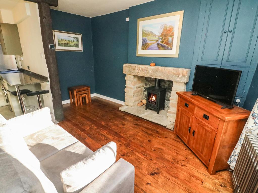 a living room with a fireplace and a tv at 1A Lower Croft Street in Settle